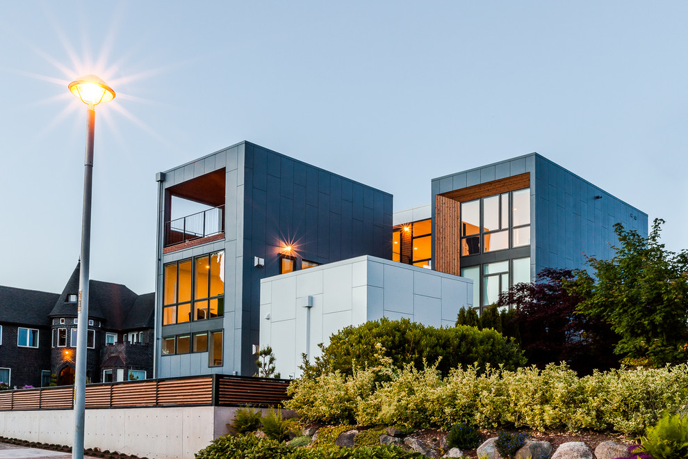 Idée de décoration pour une façade de maison bleue design à deux étages et plus.