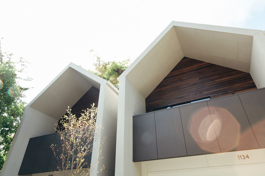 Esempio della facciata di una casa grigia moderna a due piani con rivestimento in legno