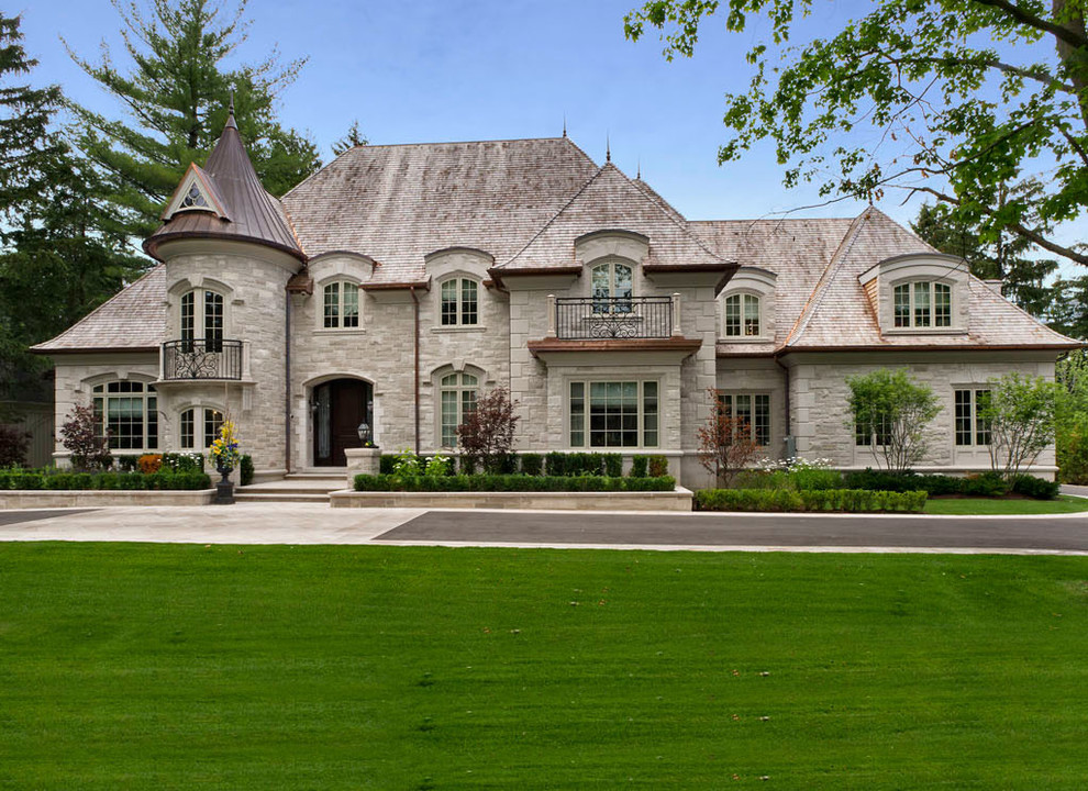Пример оригинального дизайна: большой дом в классическом стиле с облицовкой из камня и вальмовой крышей