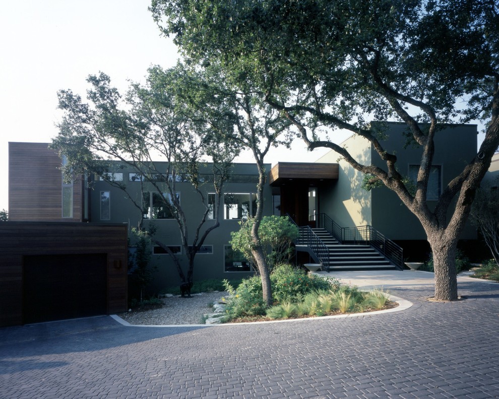 Example of a huge trendy green two-story stucco flat roof design in Austin