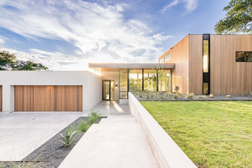 Cette photo montre une grande façade de maison beige moderne de plain-pied avec un revêtement mixte et un toit plat.