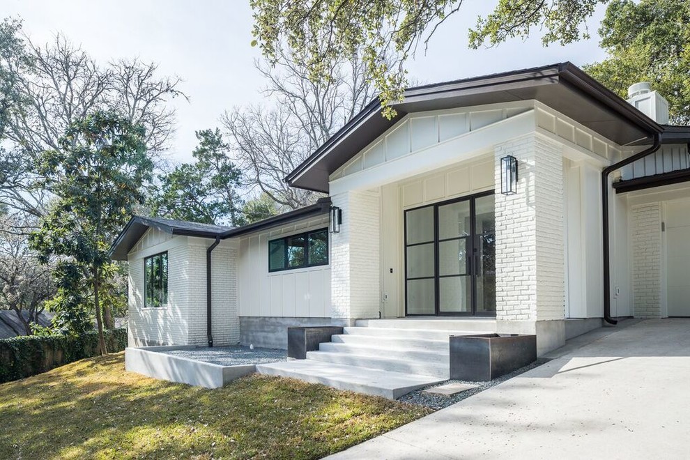 Photo of a white traditional bungalow brick house exterior in Austin with a pitched roof.