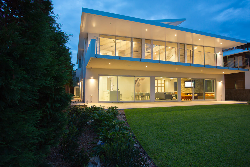 Mittelgroßes, Zweistöckiges Modernes Einfamilienhaus mit Betonfassade und weißer Fassadenfarbe in Sydney