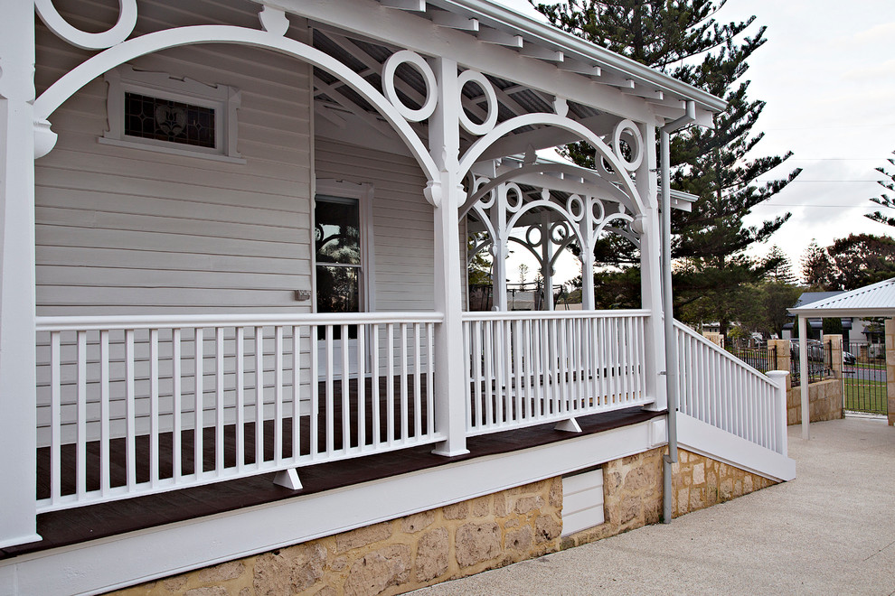Foto della villa bianca classica a due piani con rivestimento in legno, tetto a padiglione e copertura in metallo o lamiera
