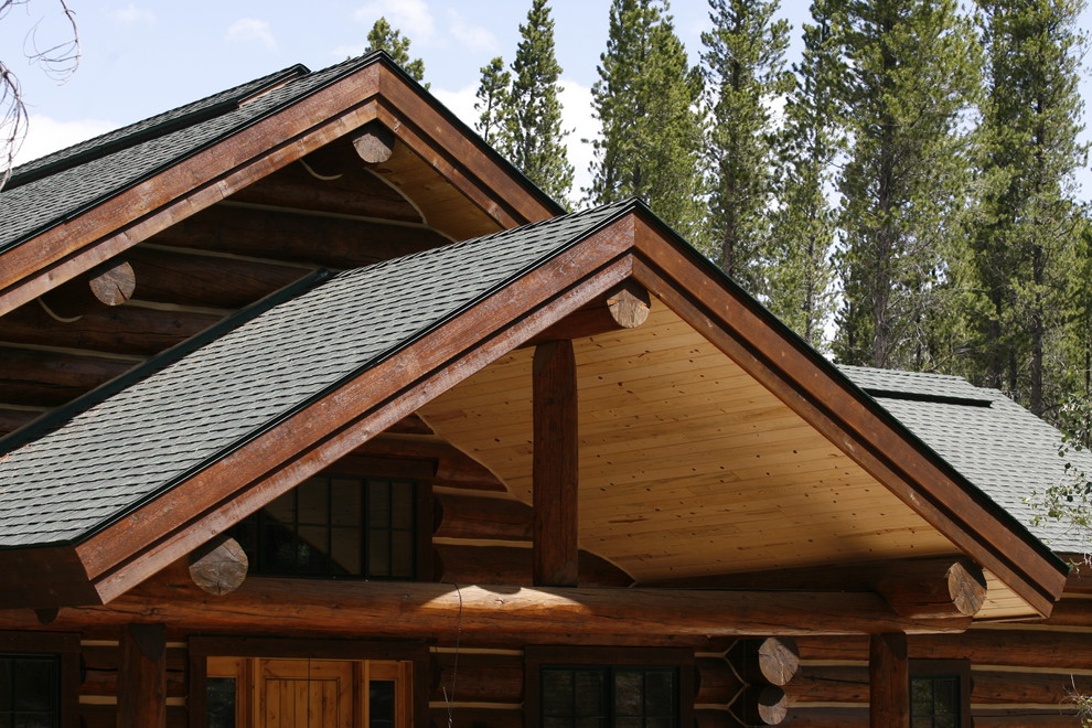 Ejemplo de fachada de casa marrón rural grande de dos plantas con revestimiento de madera, tejado a dos aguas y tejado de teja de madera