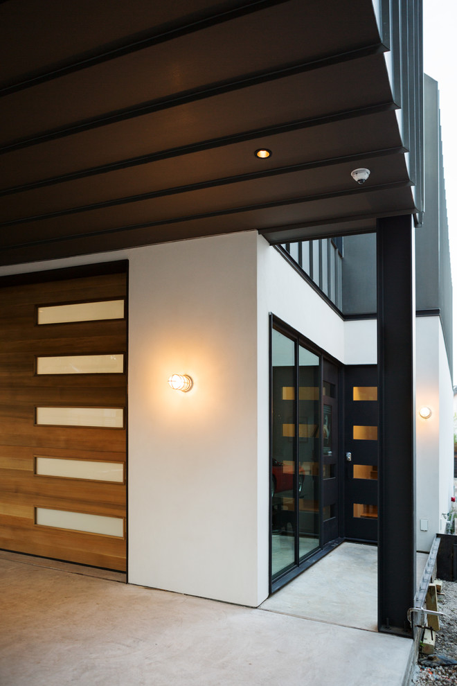 Idée de décoration pour une petite façade de maison noire minimaliste à un étage avec un revêtement mixte et un toit en métal.