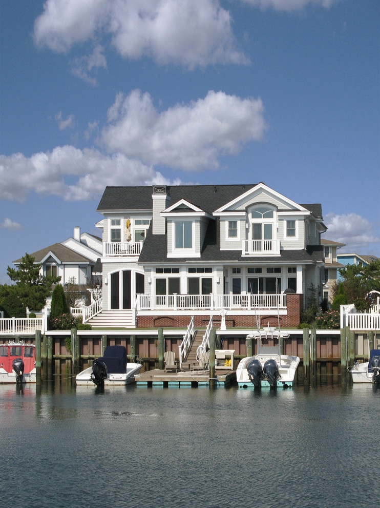 На фото: двухэтажный, серый дом в морском стиле с
