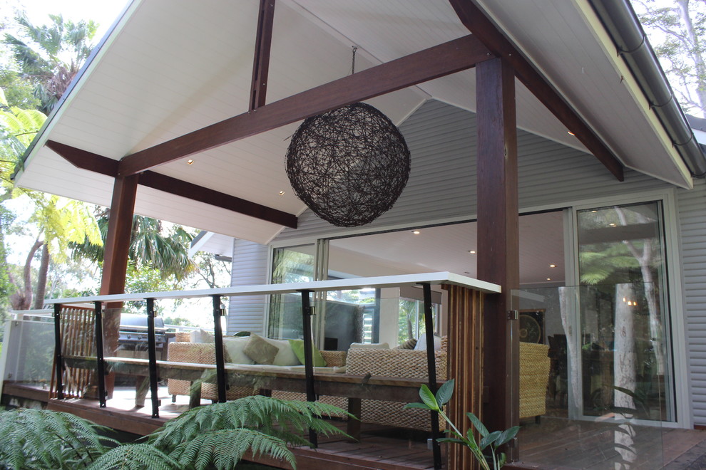 This is an example of a large and gey beach style two floor house exterior in Sydney with wood cladding.