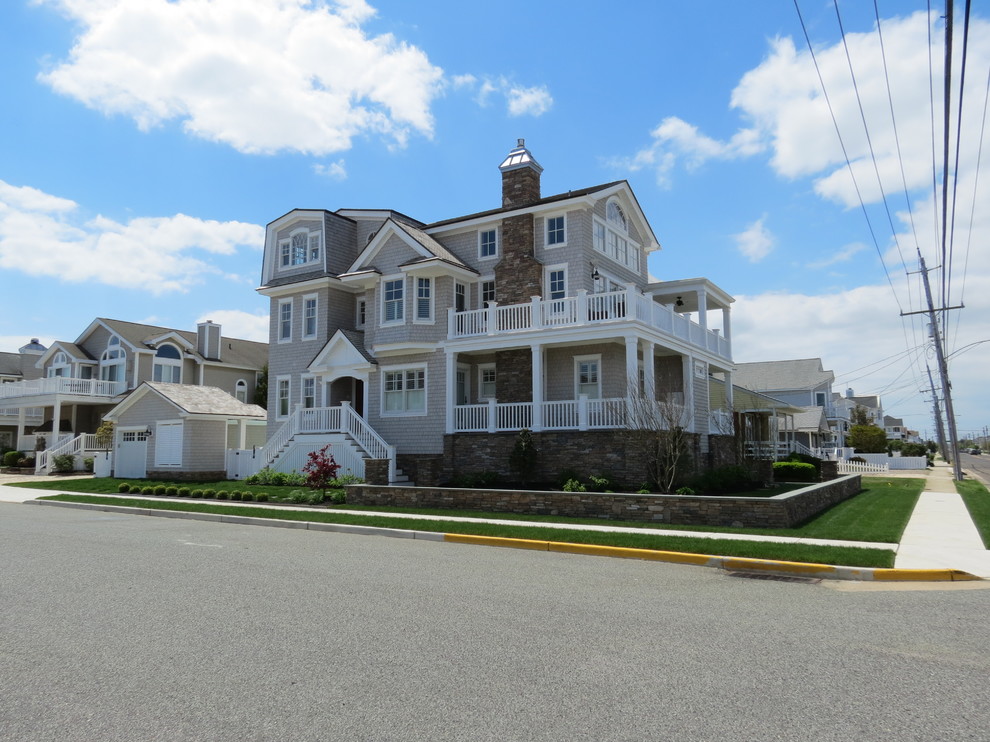 Large and beige beach style detached house in Philadelphia with three floors, vinyl cladding and a pitched roof.