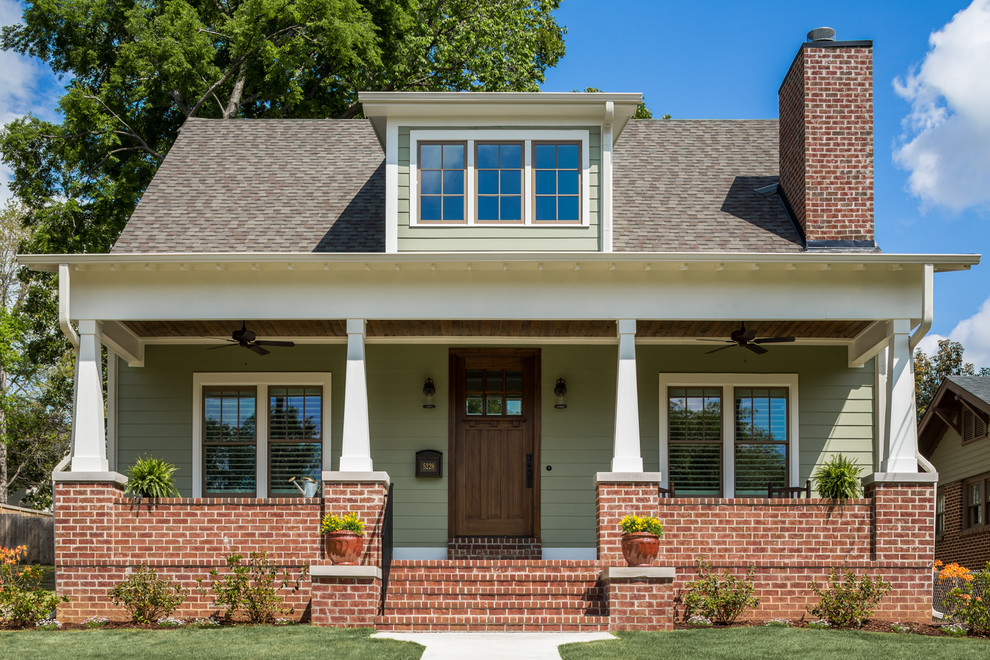 Ispirazione per la facciata di una casa verde american style a due piani con copertura a scandole, rivestimento in legno e tetto a padiglione