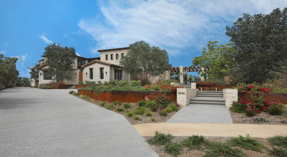 Zweistöckiges Mediterranes Einfamilienhaus mit Steinfassade, beiger Fassadenfarbe, Satteldach, Ziegeldach und rotem Dach in San Diego
