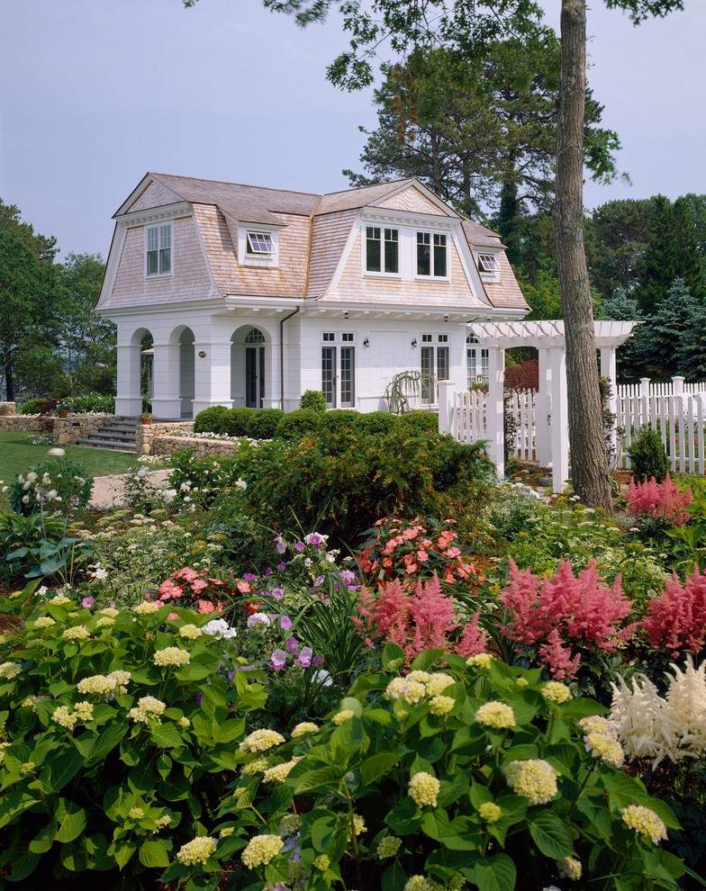 Пример оригинального дизайна: двухэтажный, деревянный, белый дом среднего размера в викторианском стиле с мансардной крышей