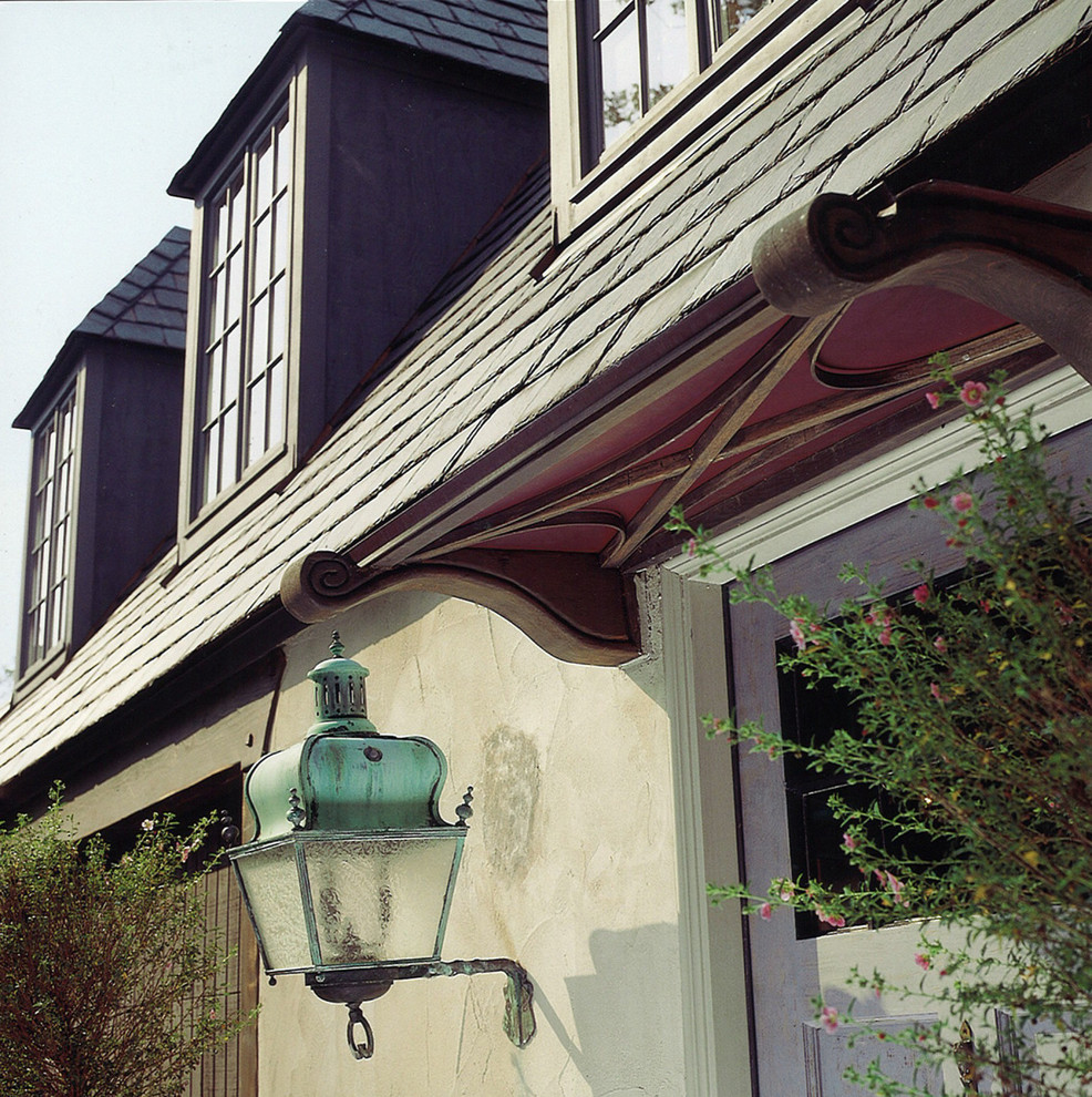 Cette photo montre une grande façade de maison grise chic en béton à un étage avec un toit à quatre pans et un toit en shingle.