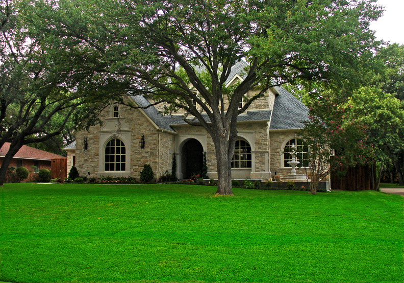 Photo of an expansive classic bungalow house exterior in Dallas with stone cladding.