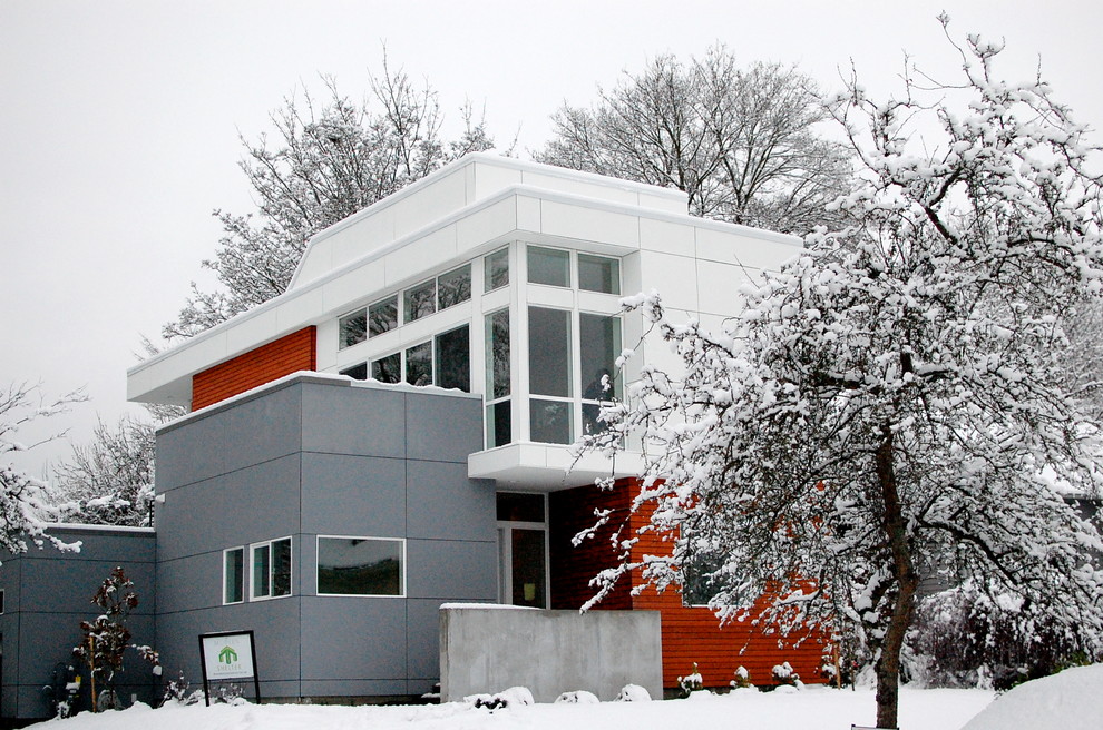 Immagine della facciata di una casa piccola rossa moderna a due piani con rivestimento in legno e tetto piano