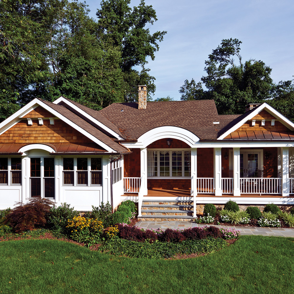 Immagine della facciata di una casa marrone classica a un piano di medie dimensioni con rivestimento in legno e tetto a padiglione