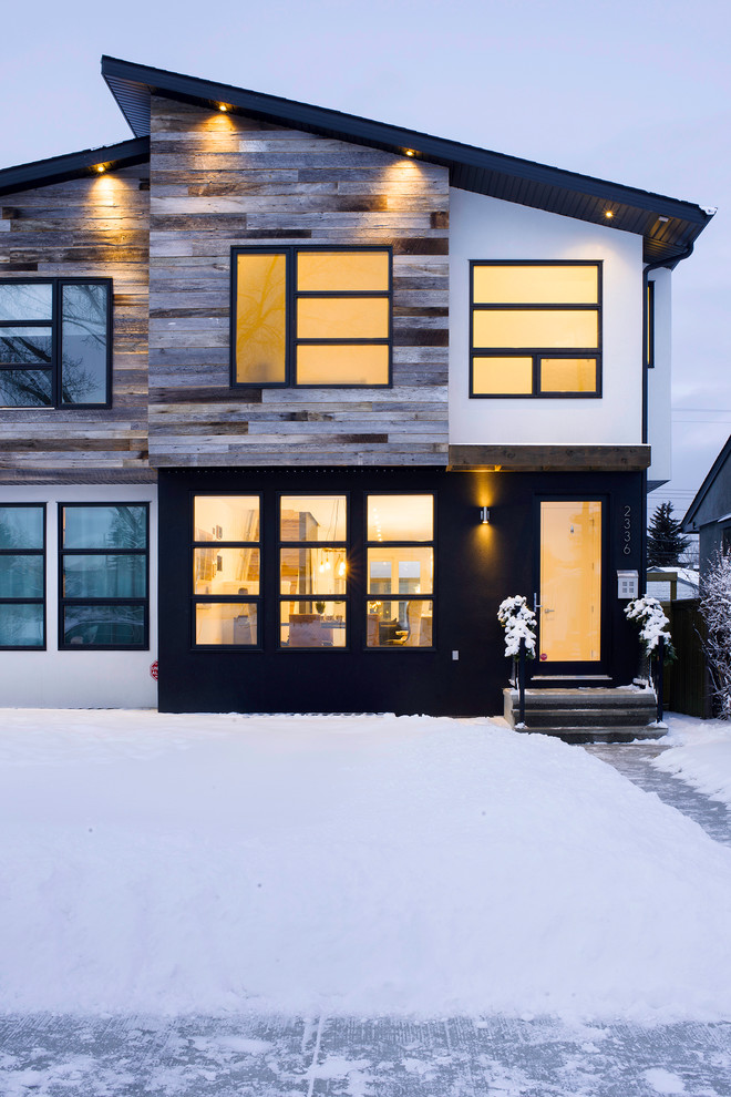 Cette image montre une façade de maison design à un étage avec un revêtement mixte.