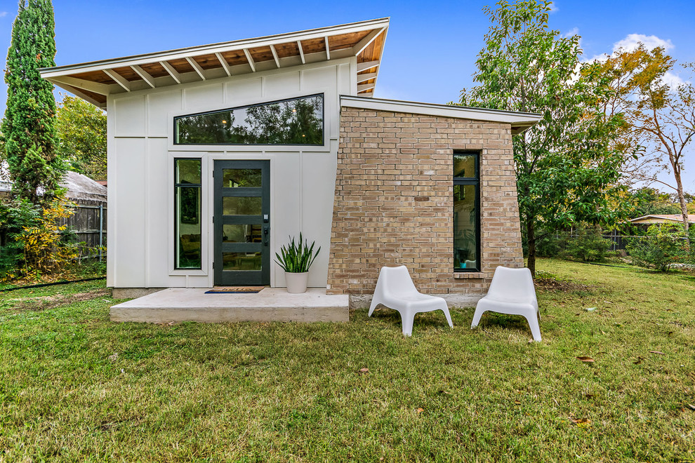 Small 1950s one-story mixed siding house exterior photo in Austin with a shed roof