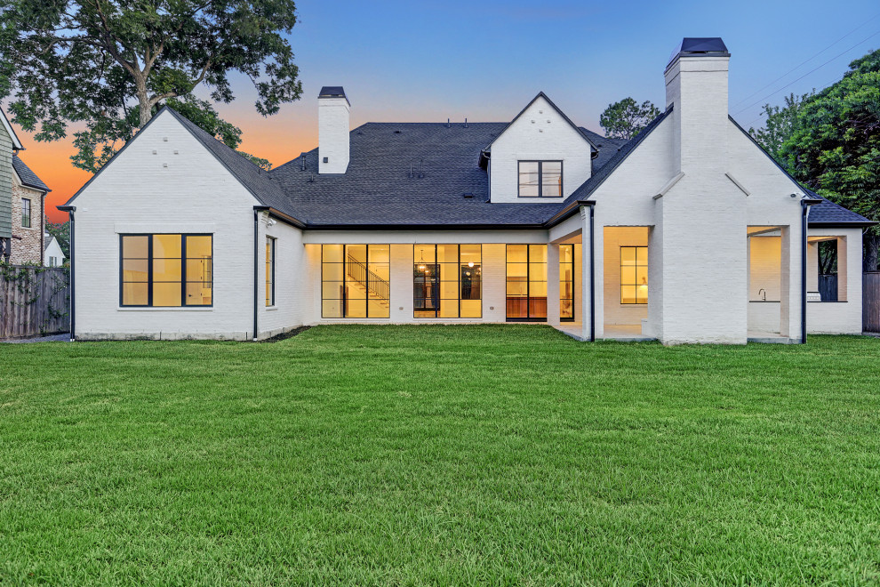 Huge transitional white two-story brick house exterior idea in Houston with a shingle roof