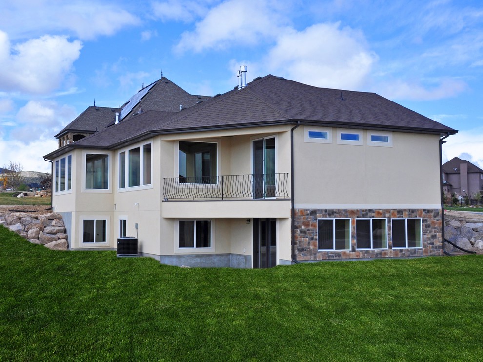 Diseño de fachada de casa beige de estilo americano de tamaño medio de una planta con revestimiento de estuco, tejado a dos aguas y tejado de teja de madera