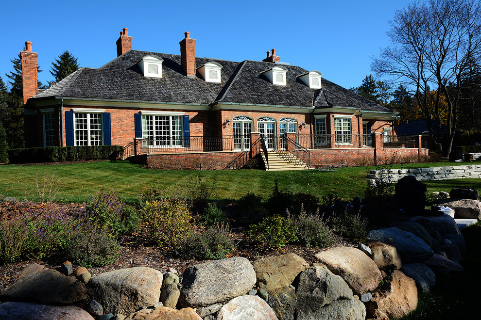 Foto della facciata di una casa grande marrone contemporanea a due piani con rivestimento in mattoni e tetto a capanna