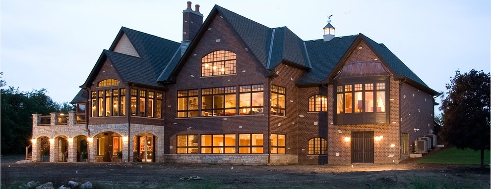 Стильный дизайн: огромный, двухэтажный, кирпичный, красный дом в стиле кантри с двускатной крышей - последний тренд