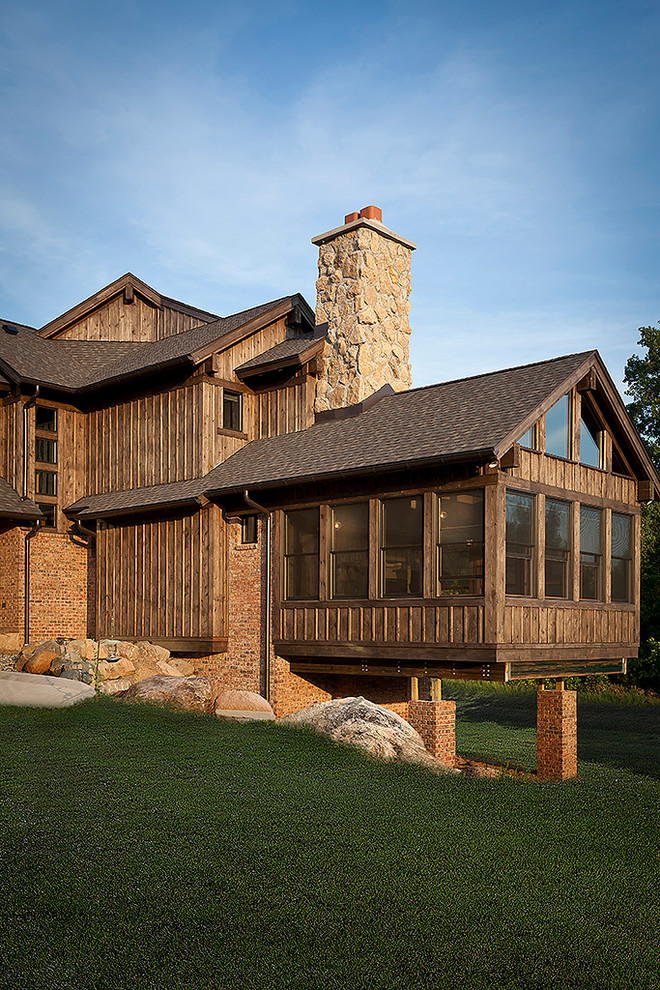 Photo of an expansive and brown rustic house exterior in Detroit with three floors and mixed cladding.