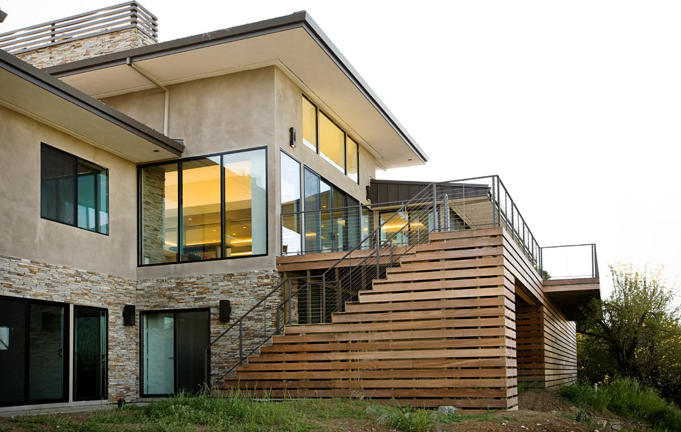 Aménagement d'une grande façade de maison beige contemporaine en stuc à deux étages et plus.