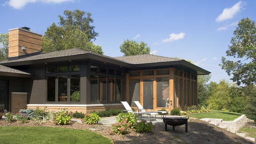 Cette image montre une grande façade de maison noire vintage de plain-pied avec un revêtement mixte et un toit à quatre pans.