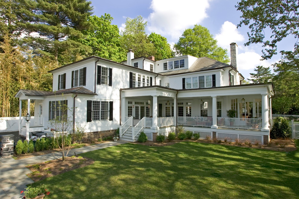 Foto della facciata di una casa grande bianca classica a tre piani con rivestimento in legno