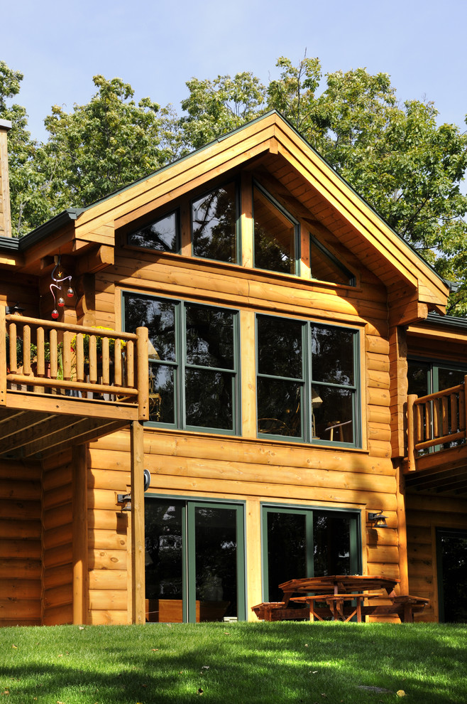 Idées déco pour une façade de maison marron montagne en bois à un étage.