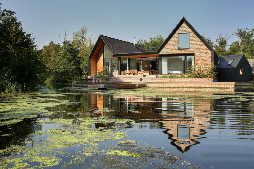 Стильный дизайн: деревянный частный загородный дом в морском стиле с двускатной крышей - последний тренд