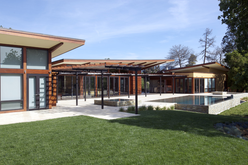 Réalisation d'une grande façade de maison design en bois de plain-pied avec un toit en appentis.