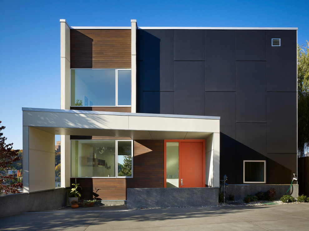 Foto de fachada gris minimalista de dos plantas con revestimientos combinados y tejado plano