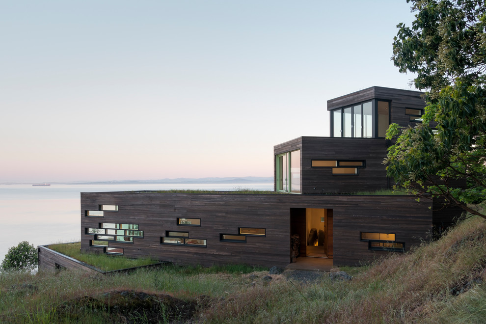 Réalisation d'une façade de maison marron design en bois de taille moyenne et à deux étages et plus avec un toit plat et un toit végétal.