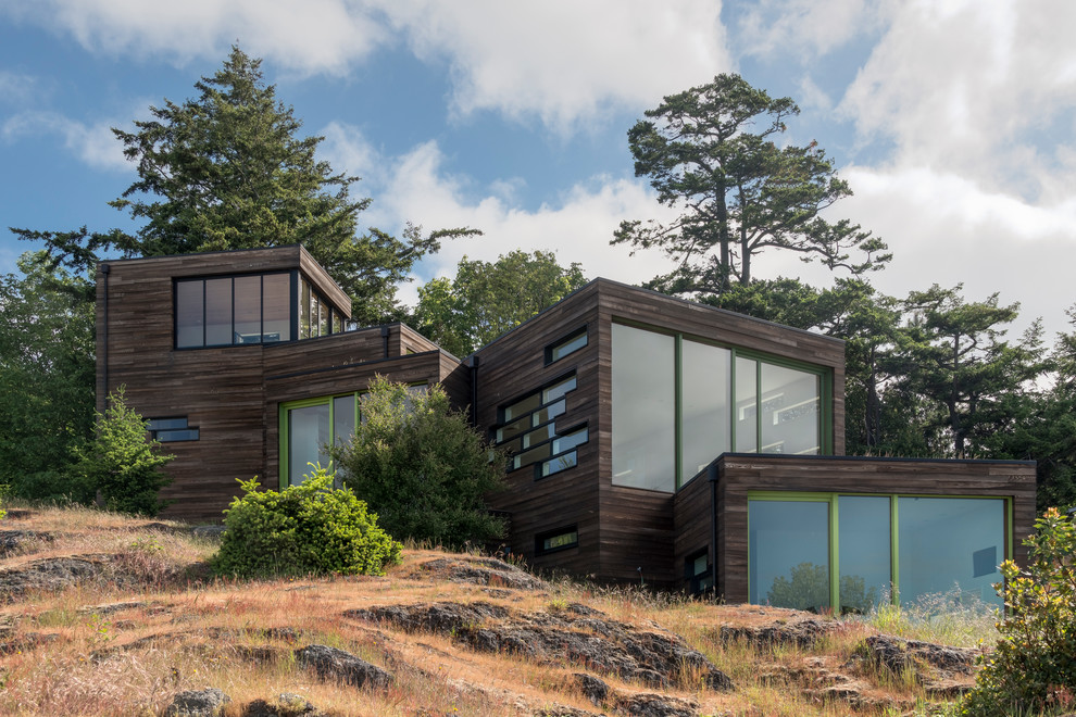Medium sized and brown contemporary detached house in Seattle with three floors, wood cladding, a flat roof and a green roof.