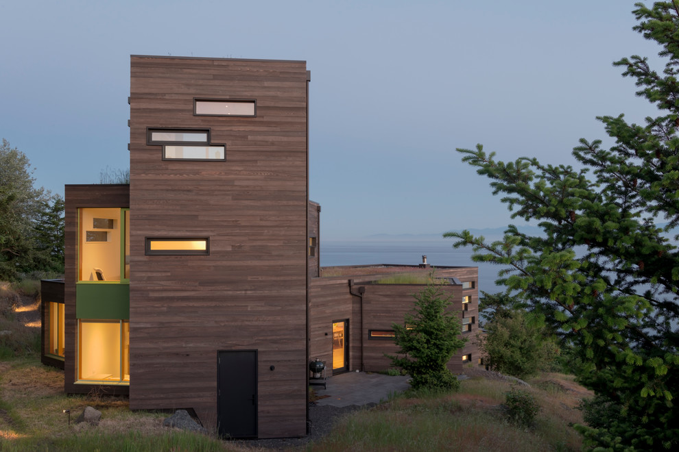 Idées déco pour une façade de maison marron contemporaine en bois de taille moyenne et à deux étages et plus avec un toit plat et un toit végétal.