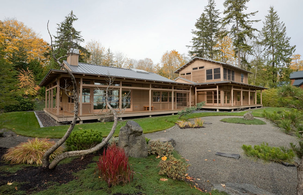 Example of a mid-sized zen brown one-story wood exterior home design in Seattle with a metal roof