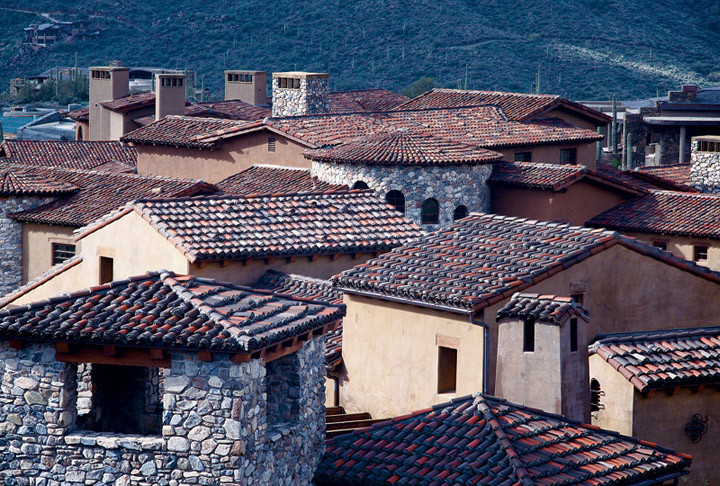 Foto della villa grande beige mediterranea a un piano con rivestimento in stucco, tetto a capanna e copertura in tegole