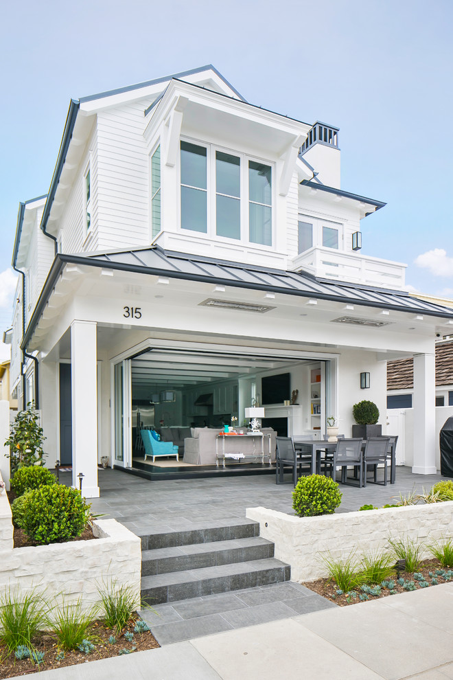 Large coastal white two-story wood exterior home idea in Orange County with a hip roof