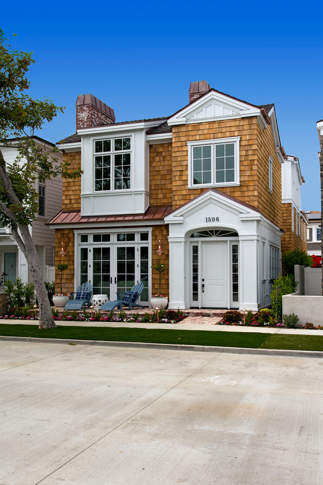 Photo of a large and brown nautical house exterior in Orange County with three floors and wood cladding.