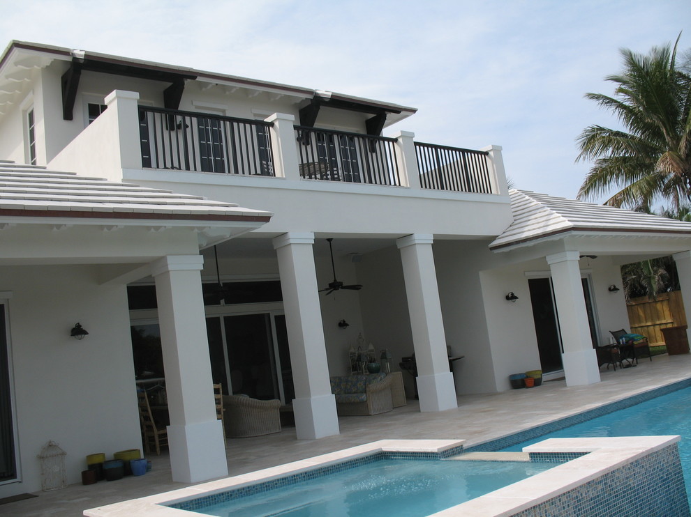 Großes, Zweistöckiges Haus mit Putzfassade, weißer Fassadenfarbe und Mansardendach in Miami