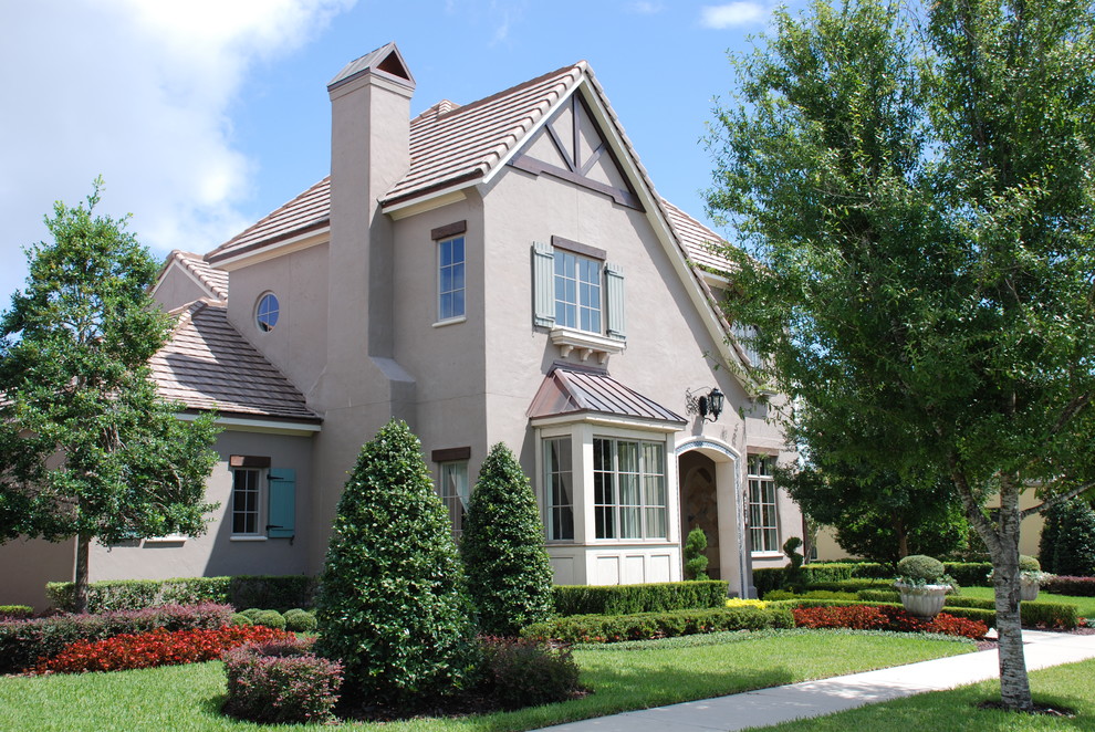 На фото: двухэтажный, серый дом среднего размера в классическом стиле с облицовкой из цементной штукатурки и двускатной крышей