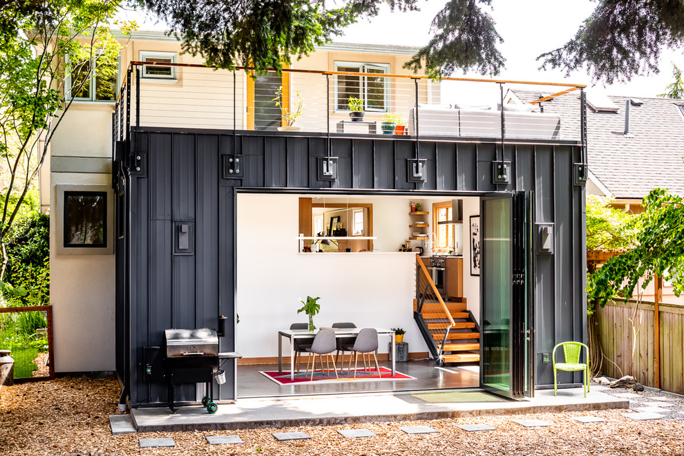 Пример оригинального дизайна: маленький, одноэтажный, серый дом из контейнеров в стиле лофт с облицовкой из металла и плоской крышей для на участке и в саду