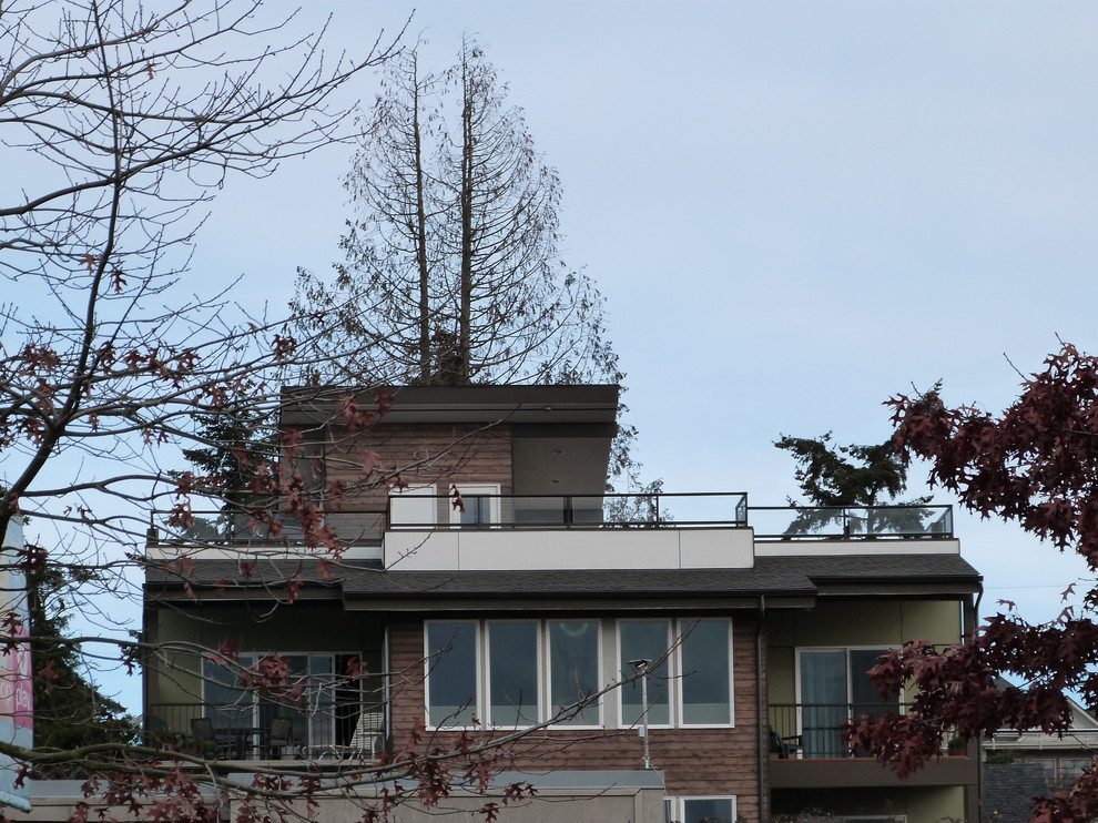 Großes, Dreistöckiges Modernes Einfamilienhaus mit Mix-Fassade, brauner Fassadenfarbe, Flachdach und Schindeldach in Seattle