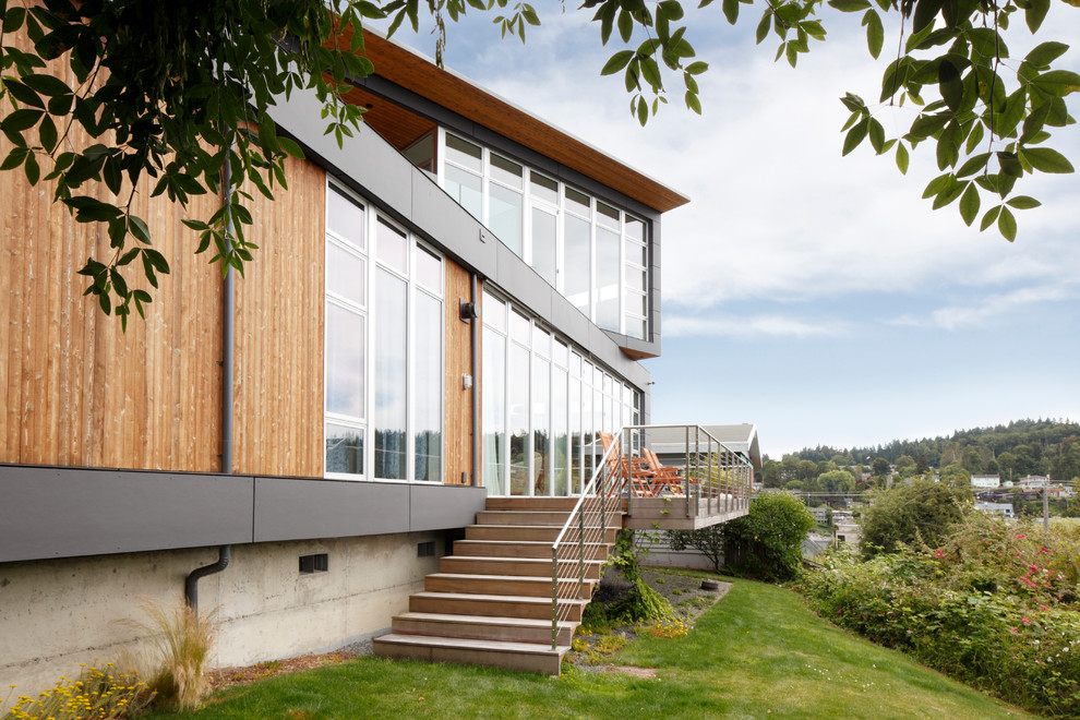 Réalisation d'une façade de maison grise minimaliste de taille moyenne et à un étage avec un revêtement mixte et un toit plat.