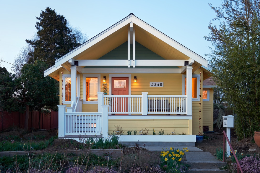 Idée de décoration pour une façade de maison jaune craftsman en bois de taille moyenne et à un étage avec un toit à deux pans et un toit en shingle.