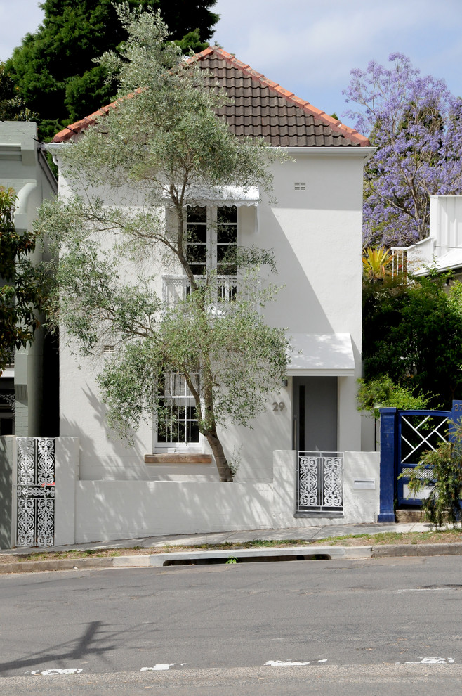 Пример оригинального дизайна: двухэтажный, белый дом среднего размера в средиземноморском стиле с вальмовой крышей