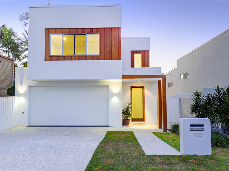 Exemple d'une façade de maison blanche tendance de taille moyenne et à un étage avec un revêtement mixte et un toit plat.