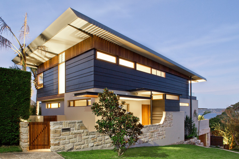 Cette photo montre une façade de maison bleue tendance à niveaux décalés avec un revêtement mixte et un toit en appentis.